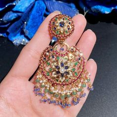 Featuring a medium sized chandbali made on gold plated sterling silver. It has been studded with red-green-blue stones that resemble rubies, emeralds and blue sapphires respectively. The elaborate hangings comprise precious pearls, emeralds and blue sapphires. The earrings close with a bombay screw. Multicolor Chandbalis With Intricate Temple Design, Bollywood Style Multicolor Chandbalis With Intricate Design, Traditional Gold Plated Multi-stone Jewelry, Traditional Multi-stone Gold Plated Jewelry, Fusion Style Chandbali Multi-stone Jewelry, Multicolor Chandbalis With Intricate Design For Celebration, Multicolor Chandbalis With Intricate Design For Festivals, Traditional Multi-stone Chandbali Jewelry, Fusion Style Multi-stone Chandbali Jewelry