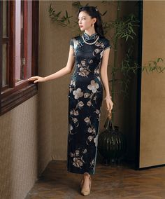 Step into elegance with this luxurious black silk qipao adorned with an exquisite floral design. The dress features a high Mandarin collar and traditional frog buttons, giving it a refined, authentic look. The rich green floral motif, interspersed with delicate cream and gold blossoms, adds a touch of nature-inspired beauty, making it perfect for formal occasions, evening events, or as a statement piece for special gatherings. Material: 90% Mulberry Silk, 10% Spandex Size Guide: Please note Asia Elegant Floral Print Cheongsam With Stand Collar, Elegant Fitted Cheongsam With Floral Print, Green Elegant Cheongsam With Stand Collar, Elegant Green Cheongsam With Stand Collar, Elegant Green Dress With Stand Collar, Elegant Ao Dai With Floral Embroidery, Elegant Floral Embroidered Dress With Stand Collar, Elegant Black Cheongsam For Spring, Traditional Floral Print Formal Dress