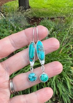 Sterling silver and two different turquoise stones have been used to make these drop earrings. Turquoise cabochons are set in silver and accented with smaller turquoise drops! They are on Sterling silver ear wires and the earrings are just about 1 1/2" long. All handcrafted by me.  Thank you for your interest and please feel free to contact me with any questions you may have. Sterling Silver Drop Earrings, Earrings Turquoise, Turquoise Stones, Silver Drop Earrings, Turquoise Stone, Ear Wires, Bend, Jewelry Earrings Dangle, Dangle Drop Earrings