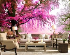 a living room with couches, chairs and a pink tree mural on the wall