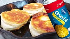 pancakes in a skillet with butter and syrup on the side, next to a can of soda