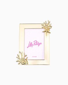 a pink and gold photo frame with a snowflake on the side, in front of a white background