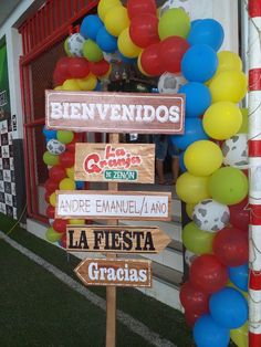 a bunch of balloons that are in front of a building with some signs on it