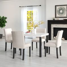 a dining room table with four chairs and a fire place in the corner next to it