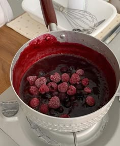 raspberries are being cooked in a pot on the stove