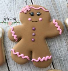 a decorated ginger cookie sitting on top of a white wooden table next to other cookies