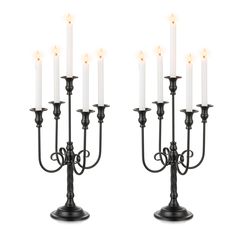 a couple of black candelabras sitting next to each other on a white background