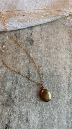 Mini brass locket on a gold fill chain. The daintiest oval shape, minimal + lovely. Can be stamped with one initial or birth flower on the inside, or filled with a picture. Dainty Round Pendant Locket Necklace With Adjustable Chain, Dainty Locket Necklace With Adjustable Chain, Dainty Locket Charm Necklace With Round Pendant, Dainty Medallion Locket Charm Necklaces, Dainty Medallion Locket Charm Necklace, Dainty Oval Pendant Locket Necklace With Adjustable Chain, Dainty Oval Locket Necklace With Adjustable Chain, Dainty Locket Necklace With Round Pendant, Dainty Yellow Gold Locket Necklace With Adjustable Chain