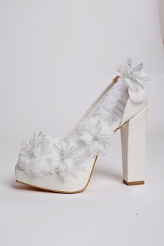 a pair of white shoes with flowers on the heel and heels are made out of satin fabric