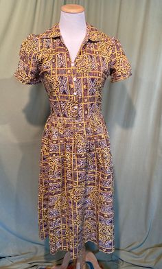 This is a cute vintage dress from the late 40s or early 50s.  No labels or tags it is home sewn. The bust measures 34", waist 26", hip 52", see measurements below.  Made of a cotton fabric in a brown, yellow, black & white busy tribal or tropical style print pattern. It has short sleeves with small, folded cuffs & ruched center panels.  It has a small V neck & pointed, split collar. No pockets.  Buttons to the waist seam down the front with 4 swirled, dome white plastic buttons. Closes on the left side with a metal zipper. It is a fit & flair shape with a gathered full skirt.  The dress is in very good condition. No repairs or damage, no soil or stains.  Sweet! Measurements were taken with the garment lying flat. If you have never worn vintage before, please measure yourself or a similar g Retro Vintage Dress With Button Closure, Retro Cotton Vintage Dress With Vintage Pattern, 1950s Style Dresses With Vintage Pattern And Short Sleeves, Fitted Retro Button-up Vintage Dress, Retro Fitted Button-up Vintage Dress, Retro Cotton Vintage Dress With Buttons, Vintage Cotton Dress With Buttons, 1950s Short Sleeve Dress With Vintage Print, Cotton Vintage Dress With Buttons