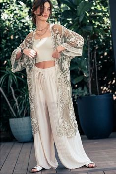 Boasting timeless elegance and luxurious comfort, the Meg Serene Palazzo Pants are crafted with an adjustable drawstring, comfortable wide leg that's woven pleated with shorts lining and a palazzo high waist elastic. Elevate your wardrobe with three sublime shades, adding a touch of coastal boho flair to your chicest ensembles. Perfectly paired with the Kate Majestic Lace Kimono, create the perfect look for any occasion. Available in Small, Medium, Large, and X-Large. Colors: Ivory Taupe Black S Lace Kimono Outfit, Taupe Outfit, Baroque Flowers, Look Kimono, The Meg, Kimono Outfits, Lace Duster, Black Palazzo Pants, Kimono Outfit