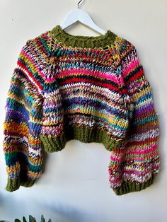 a colorful sweater hanging on a white wall