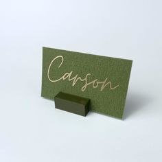 a green business card with the word cassson written on it and a rubber block