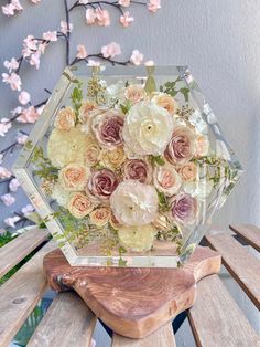 a vase filled with flowers sitting on top of a wooden bench