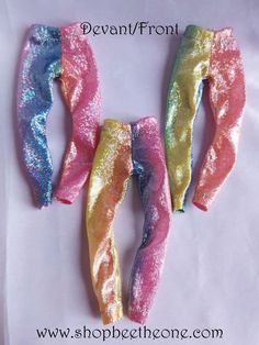 three different colored hair ties laying next to each other on top of a white sheet