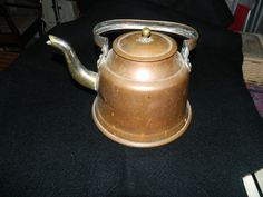 an old tea kettle sitting on top of a table