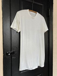 "An authentic vintage blank white t shirt army issue dated 1976 era : 1970s  material : cotton color : white condition : distressed, appropriate signs of age and wear as seen in photos which may include small spots, pin sized holes, and other imperfections  size : approx mens large , please compare measurements below actual garment measurements : chest : 20.5\" pit to pit  length : 30\" - - - - - - - - - - - - - - - - - - - - - - - - - - - - - - - - - - - - - - - -  INTERNATIONAL SHIPPING AVAILA Distressed White Short Sleeve T-shirt, White Distressed Crew Neck Top, White Distressed Short Sleeve T-shirt, White Distressed Short Sleeve Tops, White Distressed Top For Everyday, Vintage Washed White T-shirt, White Washed T-shirt For Everyday, Distressed White Cotton Tops, White Washed Short Sleeve Tops