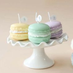 three macaroons are sitting on a cake plate