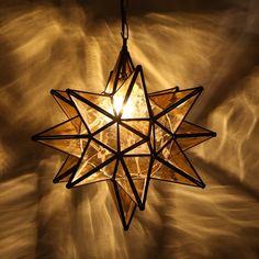 a star shaped light hanging from a ceiling