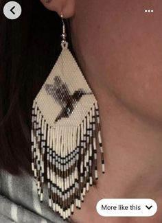 a close up of a woman's face wearing large earrings with beaded fringes