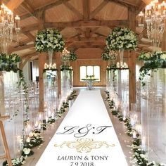 a long table with flowers and candles on it in the middle of an indoor venue