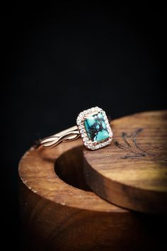 a close up of a ring on top of a wooden table with a black background