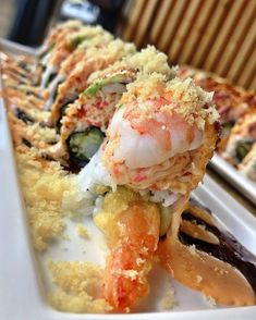 a white plate topped with different types of sushi and other foods on top of it