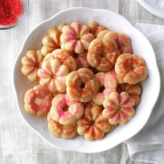 a white bowl filled with donuts on top of a table