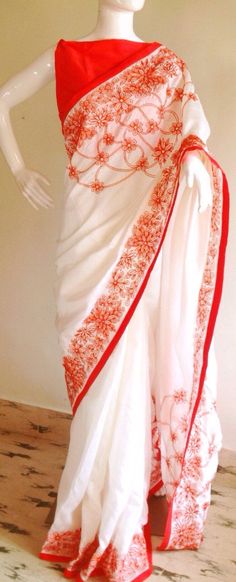 "Stunning half white semi silk saree with intricate all over embroidery and semi raw silk unstiched blouse in reddish orange. The red color thread embroidery is simply stunning aginst offwhite. The entire embroidery is hand worked and the floral border extends more in the front, pallu and the pleats. Saree length 5.5 meters Blouse fabric 1 meter 44\" wide Saree ships in 2-3 days of payment. Delivery within 4-5 days of shipment all over the world. We also offer blouse and petticoat stitching for Red Pre-draped Saree With Embroidered Border For Festivals, White Silk Pre-draped Saree With Zari Work, Traditional Red Pre-draped Saree With Resham Embroidery, Traditional Red Embroidered Pre-draped Saree, Traditional Red Pre-draped Embroidered Saree, White Cutdana Pre-draped Saree For Puja, White Tussar Silk Pre-draped Saree For Diwali, White Art Silk Pre-draped Saree For Festivals, Embroidered White Pre-draped Saree For Festivals