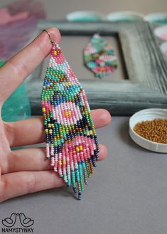 a hand holding a beaded christmas tree ornament