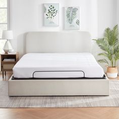 a white bed with a mattress on top of it