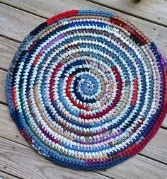 a multicolored round rug sitting on top of a wooden floor