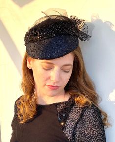 If you are looking for a black wedding hat  consider buying this one of a kind handmade piece . The base is covered with a chic fabric and black lacey tulle and the yet hat is very light. Attaches to the head with an easy to wear elastic that sits under the hair in the back. Similar hats can be found in our store in several colors. Contact me if u need help. For a larger selection:  https://www.etsy.com/il-en/shop/RanaHats?ref=simple-shop-header-name&listing_id=1359859956§ion_id=1&page=2#items R Hat For Wedding, Mother Of The Bride Hats, Black And White Hats, Dressy Hats, Occasion Hats, Church Hat, Bride Hat, Bridal Hat, Wedding Hat