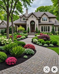 a house with landscaping around it and trees in the front yard, surrounded by flowers