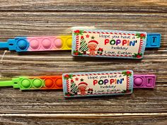 two colorful plastic spoons sitting next to each other on top of a wooden table