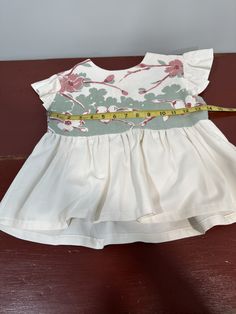 Handmade with cast off vintage tablecloth. You can just tell this is vintage by the floral pattern style and the quality of the fabric.   See pictures for measurements - this dress is shorter than most of my dresses.  Would be very cute styled with leggings and boots, or tights and Mary Jane shoes.  Much love goes into the design and execution of all my work.  All of my work is made primarily with upcycled materials.  I try to work around flaws in these vintage reclaimed articles.  Some imperfections are to be expected.  Especially with the vintage table linens.  It is part of the charm.   Please contact me immediately if you are dissatisfied with this this garment.   Thank you for visiting my Etsy shop. White Floral Patchwork Short Sleeve Dresses, Vintage White Fitted Sundress, White Fitted Vintage Sundress, White Floral Dress With Flutter Sleeves For Garden Party, Cotton Floral Dress With Flutter Sleeves And Ruffles, Vintage White Floral Print Sundress, White Vintage Floral Print Sundress, Vintage White Sundress With Floral Print, White Cotton Lined Vintage Dress