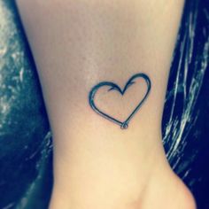 a small heart tattoo on the ankle