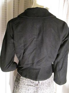 "1950's ladies petite waist clinching little jacket made in Italy. Front plastic front buttoned, big flip collar, flap back waistline with side buttoned flaps, dolman sleeves, rayon fully lined, in light wool fabric. Jacket outside is in good condition, but black rayon lining is slightly aging color changed, the buttons have a center scratch where maybe they once had a stone or something in each center . Bust about 36\"-38\", Waist 28\", Neckline about 14 1/2, and Jacket Length 19\". PRICE is $3 Fitted Collared Pea Coat For Winter, Fitted Collared Party Outerwear, Fitted Collared Outerwear For Party, Fitted Collared Blazer For Winter, Semi-formal Black Cropped Jacket For Fall, Black Semi-formal Cropped Jacket For Fall, Black Cropped Jacket For Semi-formal Fall Occasions, Fitted Collared Blazer With Buttons, Fitted Single Breasted Cropped Jacket For Tailoring