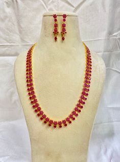 **Ruby Enamel Choker Set** - **Polish Gold plated, offering a traditional yet elegant look. - **Stones Ruby-colored simulated stones beautifully set in an enamel design that blends modern and traditional elements. - **Design The necklace features an intricate pattern of Round ruby stones, set in a unique fan-shaped pendant design with matching earrings. The curved necklace complements the neckline perfectly. - **Style Indian Traditional Jewelry - Perfect for weddings, special occasions, or festive celebrations. - **Dimensions    - **Necklace Length 20 inches (plus an adjustable back chain for comfort).   - **Earring Length 2 Inches. - **Handmade Every stone is set by hand, ensuring the highest level of craftsmanship and attention to detail. This piece is an excellent choice for those seeki Ruby Necklace Gold, Gold Plated Jewelry Indian, Jewelry Indian Wedding, Elements Design, South Indian Jewelry, Ruby Necklace, Jewelry Indian, Indian Traditional, Wedding Jewellery Necklace