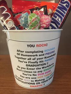 a bucket filled with candy and candies on top of a wooden table