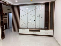 an empty room with white tile floors and wooden accents on the wall, along with shelving units