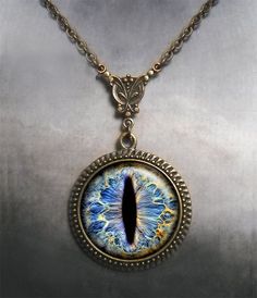 "Frost Dragon Eye Steampunk necklace (Listing 94) Amaze your friends at your next RuneScape or D&D session with this colorful Frost Dragon Eye necklace! It's been set into an Art Nouveau styled necklace for a unique bit of Victorian Steampunk vibe. We have 5 chain length available at checkout (18\", 21\", 24\", 27\" or 30\") and custom lengths are available upon request. Pendant measures 1-3/16\" across (30mm) and the artwork is covered by a crystal clear, domed glass cabochon which protects Adjustable Fantasy Necklaces For Fantasy Events, Adjustable Fantasy Necklace For Fantasy Events, Fantasy Metal Pendant Jewelry, Gold Fantasy Style Necklace For Fantasy Events, Fantasy Metal Necklaces For Collectors, Fantasy Metal Pendant Necklace, Fantasy Pendant Jewelry For Fantasy Events, Metal Dragon Design Jewelry Gift, Dragon Design Jewelry For Gift