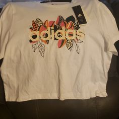 Nwt Ladies Sz Large Tshirt With Flower Design Adidas T-shirt For Spring Streetwear, Spring Graphic Tee Cropped T-shirt With Logo Print, Spring Graphic Tee With Logo Print, Spring Logo Print Short Sleeve Tops, Trendy Adidas T-shirt With Letter Print, Trendy Adidas T-shirt For Spring, White Top With Front Print For Spring, White Tops With Front Print For Spring, Adidas Cotton Crew Neck Top