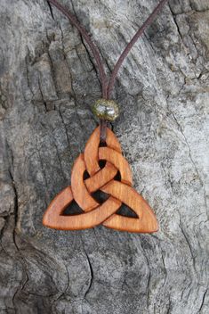 This beautiful and unique hand-carved Triquetra necklace will be made for you, or a loved one, in my studio on the West of Ireland. Adorned with a lovely beige ceramic bead, this intricate large Infinity knot Celtic pendant features a piece of Irish Cherry wood, recycled from musical instruments constructed by a local luthier. As a musician myself, I take enormous satisfaction in creating a necklace whose inherent wood has previously featured in a beautiful hand-made harp. To the ancient Celts, Symbolic Carved Brown Jewelry, Brown Carved Spiritual Jewelry, Spiritual Brown Carved Jewelry, Triquetra Necklace, Pendant Designs, Ancient Celts, Wood Items, Beige Ceramic, Celtic Pendant