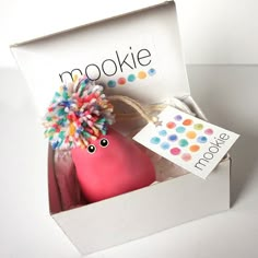 a pink toy with a pom - pom on it's head in a box