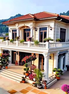 a large white house with lots of flowers on the front and side balconies