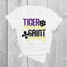 Soft t-shirt with CJ's Tees original LSU/Saints design. Shirts are unisex and fit true to size. Lsu Shirts Vinyl Women, Graphic Tee T-shirt With Text Print For Fans, Graphic Tee With Text Print For Fan Gear, White Graphic Tee For College, Relaxed Fit Text Print T-shirt For Fan Gear, Relaxed Fit T-shirt With Text Print For Fans, Relaxed Fit Text Print T-shirt For Fans, College T-shirt With Sublimation Print And Relaxed Fit, College Graphic Tee Shirt With Sublimation Print