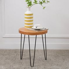 a small table with a vase and some plants on it