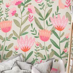 a floral wallpaper with pink flowers and green leaves on a white background in a child's bedroom