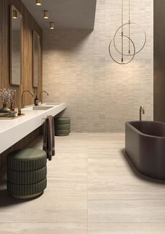 a large bathroom with two sinks and a tub in the middle, along with mirrors on the wall